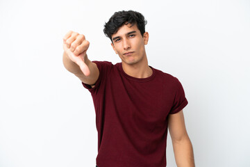 Young Argentinian man isolated on white background showing thumb down with negative expression