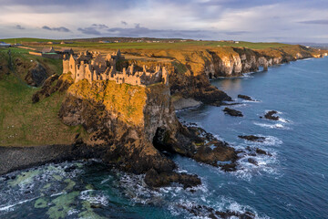 Fototapeta na wymiar Aerial view with Dunluce Castle, the famous fortress in ruin in Northern Ireland UK, seen at sunrise