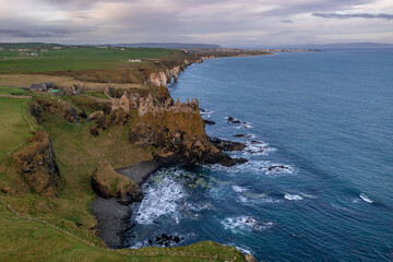 Aerial view with Dunluce Castle, the famous fortress in ruin in Northern Ireland UK, seen at sunrise
