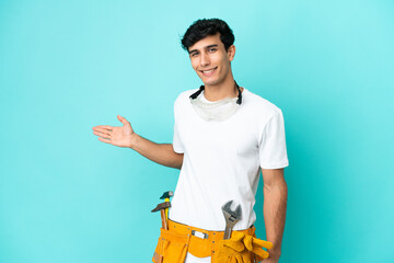Young electrician Argentinian man isolated on blue background extending hands to the side for inviting to come