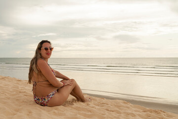 Woman with her back on dune at sunset. Girl in Jericoacoara dune. Travel concept. Jericoacoara concept.