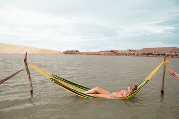 Woman in a hammock at Tatajuba Lagoon in Jericoacoara Brazil. Jericoacoara concept. Woman concept.