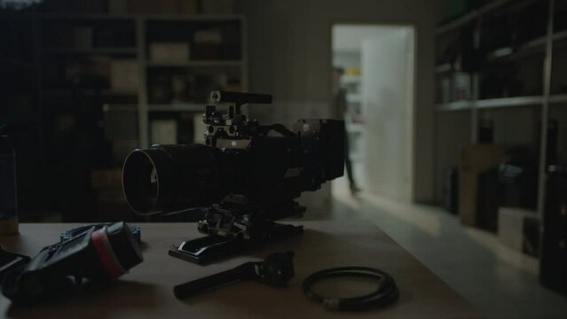Camera Rental house. Top Digital camera is on the foreground. Camera man entering the door on the background 