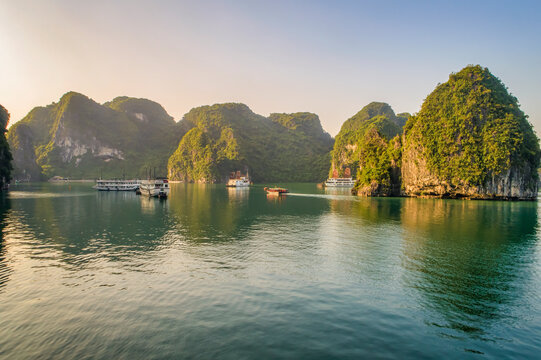 AERIAL VIEW FLOATING FISHING VILLAGE AND ROCK ISLAND, HALONG BAY, VIETNAM, SOUTHEAST ASIA. UNESCO WORLD HERITAGE SITE. JUNK BOAT CRUISE TO HA LONG BAY. POPULAR LANDMARK, FAMOUS DESTINATION OF VIETNAM