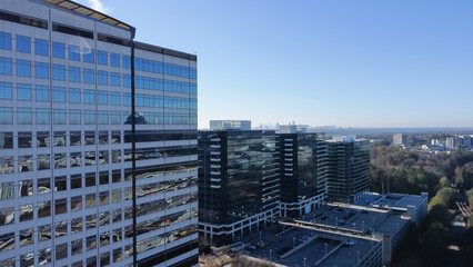 Top view modern glass wall corporate buildings at Tech Square neighborhood with Atlanta downtown skyscrapers in background