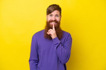 Redhead man with beard isolated on yellow background showing a sign of silence gesture putting finger in mouth