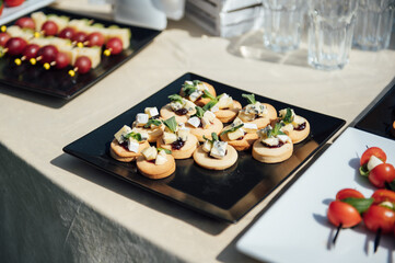 Sandwiches, canapes and cakes on the festive table. A wide variety of snacks