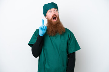 Surgeon redhead man in green uniform isolated on white background thinking an idea pointing the finger up