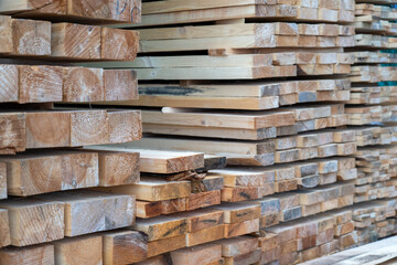 Wooden planks at lumber warehouse. Piles of wooden boards at store outdoors. Wood timber stack of wooden planks construction material.