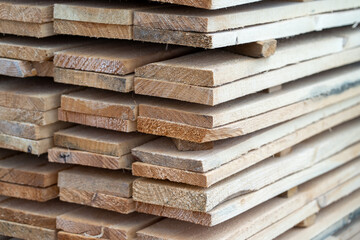 Wooden planks at lumber warehouse. Piles of wooden boards at store outdoors. Wood timber stack of wooden planks construction material.