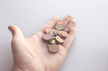 A handful of small pocket euro cent coins in a man's palm. First-person view. The concept of lack...