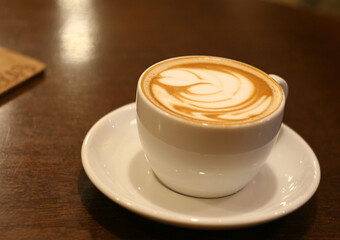 Cappuccino coffee in a mug is on the table. This is a coffee shop