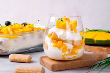 Trifle dessert with mango and ladyfinger cookies served in a glass. Tiramisu cake variation - 549446676