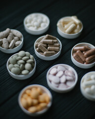 pills in small plates on a dark background