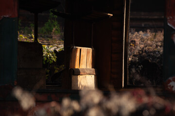 Obraz premium An abandoned train seat in a carriage. A wooden bench is lit by a ray of sunlight. the wagon is abandoned, there are no more windows or doors.
