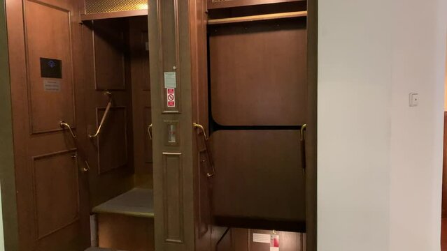 Motion of wooden vintage open, no door paternoster lift at Prague's New city hall.  Tourists very often comes to see this rare elevator technology. Prague, Czech Republic