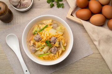 Clear soup with fried egg and minced pork ,Chinese Cabbage in white bowl.Top view