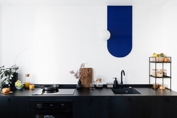 modern interior in kitchen with black furniture and white wall