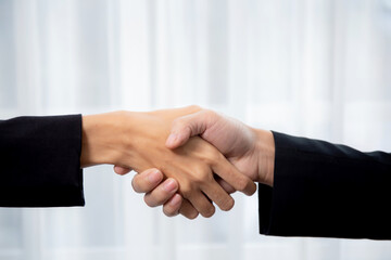 Closeup hand of business man and woman standing and shake hands while agreement of negotiation success and congratulations at office, businessman and partner handshake while greeting together.