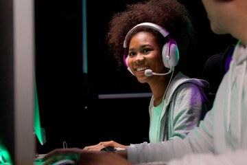 Young African American woman and asian man wearing headset play video game and live streaming online with microphone, gaming and esport for competition or casting game, entertainment concept. © NT_studio