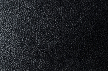 The texture of Black leather with shadow as background.