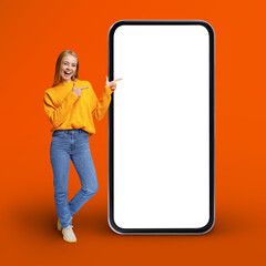 Great App. Positive Young Woman Pointing At Huge Blank Mobile Phone