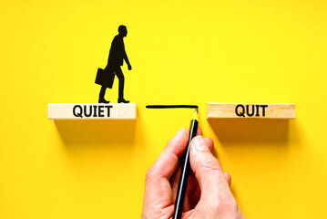 Quiet quit symbol. Concept words Quiet quit on wooden blocks. Beautiful yellow table yellow background. Businessman hand. Businessman icon. Business and quiet quit concept. Copy space.