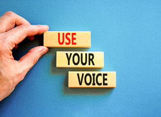 Use your voice symbol. Concept words Use your voice on wooden blocks on a beautiful blue table blue background. Businessman hand. Business and use your voice concept. Copy space.