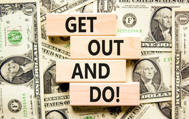 Motivational get out and do symbol. Concept words Get out and do on wooden cubes. Beautiful background from dollar bills. Business motivational get out and do concept. Copy space.