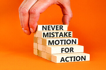 Mistake or action symbol. Concept words Never mistake motion for action on wooden blocks. Businessman hand. Beautiful orange table orange background. Business mistake or action concept. Copy space.