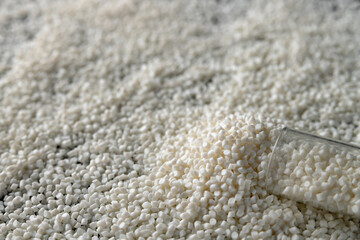 Close-up of plastic polymer granules, hand hold Polymer pellet, polymer plastic, compound polymer,...