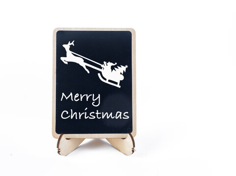 small black chalk board with happy Christmas message and flying Father Christmas graphic on a white background