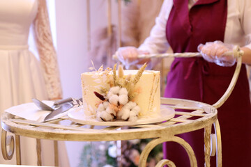 A beautiful wedding cake is taken to the bride and groom in a cart.