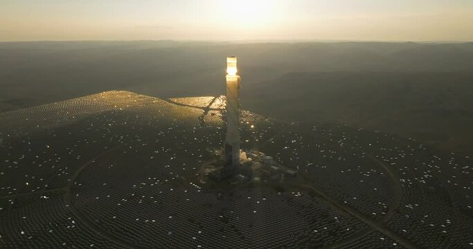 Hydroelectric Solar tower power station at sunrise in a desert landscape