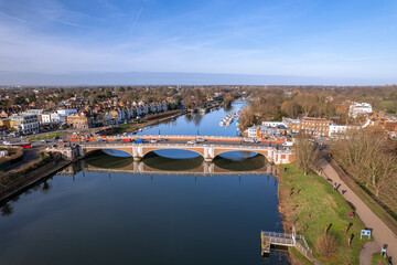 The drone aerial view of Hampton Court bridge and Thames river. Hampton Court Bridge crosses the River Thames in England between Hampton, London and East Molesey, Surrey. - obrazy, fototapety, plakaty