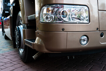 A big truck on the road. Modern new halogen headlights on a truck. Truck headlights.  Square red headlight and reflector on the back of the hood. Car detail, close-up.