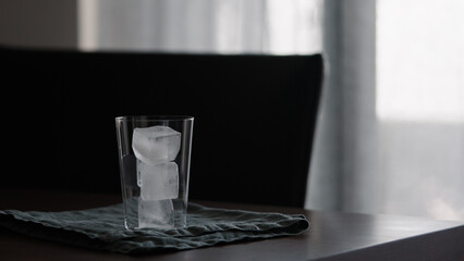 man making iced coffee with milk in thumbler glass on walnut table