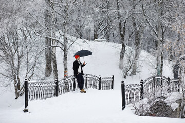 Winter walk with an umbrella.Man in a coat with an umbrella, walk against the backdrop of the winter landscape, winter view