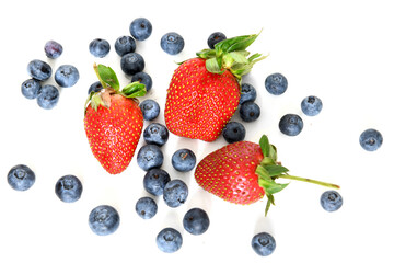 Delicious, ripe strawberries and blueberries on light background