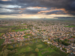Dramatic view of a typical English town showing new homes around the old town. Seen against a dramatic sky with a distant wind farm just in view.