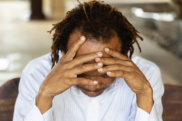 depressed middle age African man doing face palm gesture