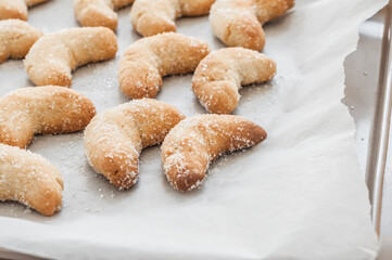 Shortbread tasty cookies in the form of crescents on backing paper.