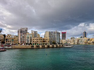 Dark clouds over the buildings at Balluta Bay and Spinola Bay both in the town San Giljan (St. Julian's) in Malta. 