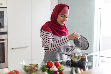Middle eastern wife cooking rice on stove at kitchen
