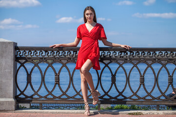 Portrait of a young beautiful brunette woman in a short red dress