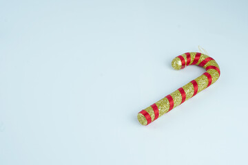 Gold and red candy canes with glitter on white background