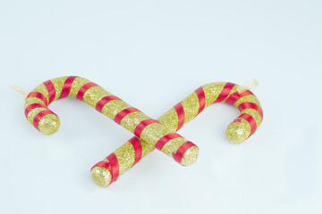 Gold and red candy canes with glitter on white background