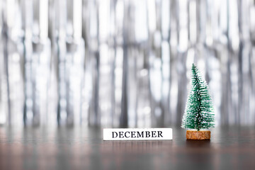 Christmas tree and word december on silver background with copy space. Merry xmas and Happy new...