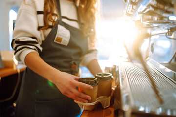 Сoffee to go. Young barista girl smiling happy holding take away coffee at the cafe shop.