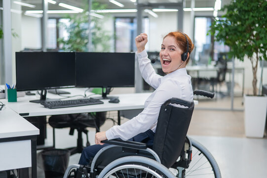 Caucasian woman with headset in a wheelchair. Happy female call center worker in the office.